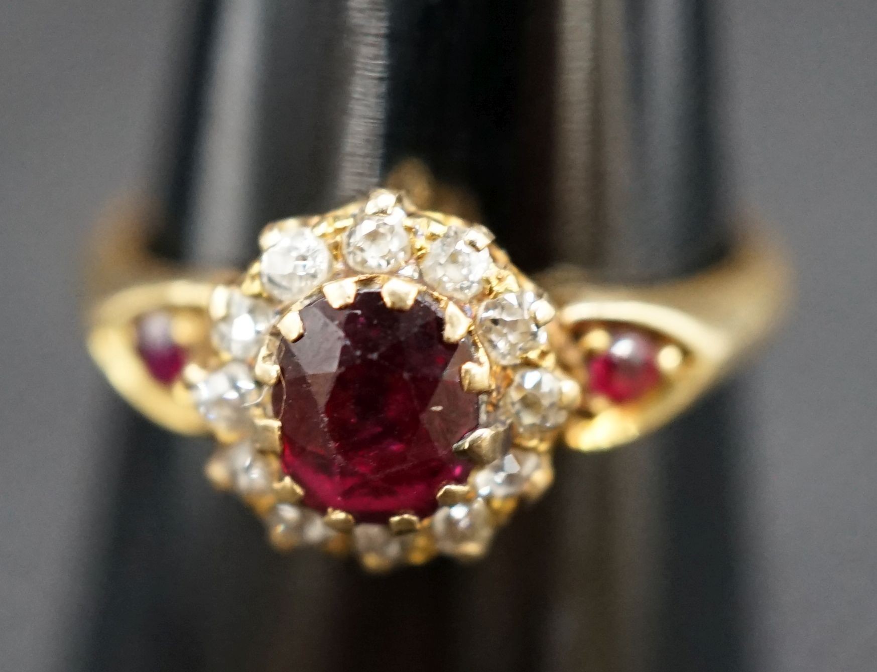 A late Victorian 18ct gold ruby and diamond cluster ring, with ruby set shoulders, size M, gross weight 2.7 grams.